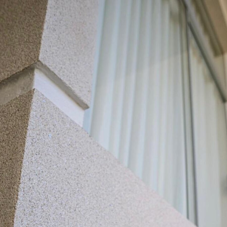 Detalhe aproximado da textura do revestimento acrílico em tom areia